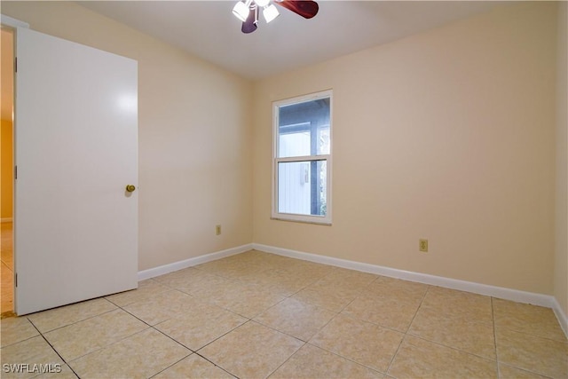 spare room with light tile patterned flooring, baseboards, and ceiling fan