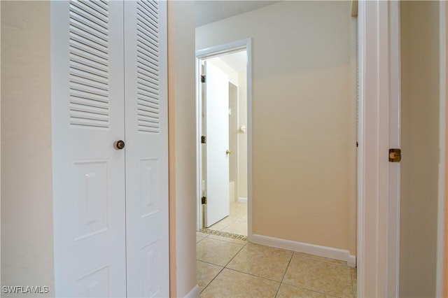 hallway with baseboards and light tile patterned flooring