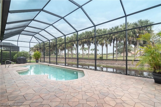 outdoor pool with glass enclosure and a patio