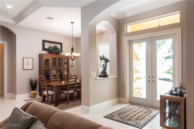 foyer featuring light tile patterned flooring, visible vents, french doors, and a chandelier