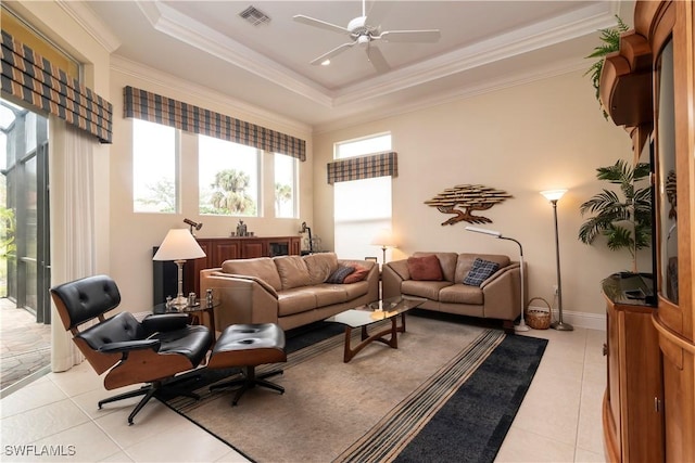 living area with crown molding, light tile patterned floors, visible vents, and a tray ceiling