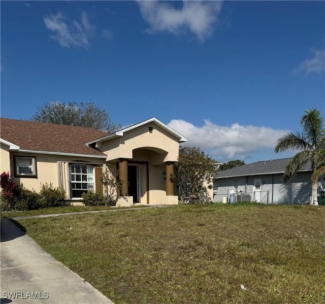 view of front facade featuring stucco siding and a front lawn