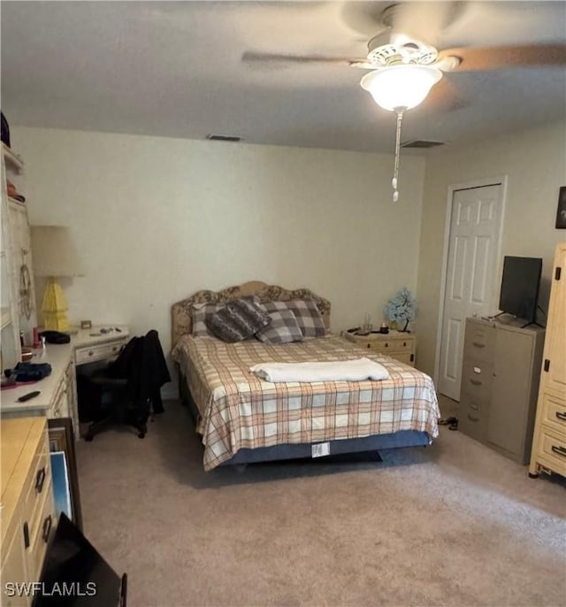 bedroom with a ceiling fan, light colored carpet, and visible vents