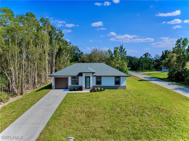 view of front of home with an attached garage, concrete driveway, and a front lawn