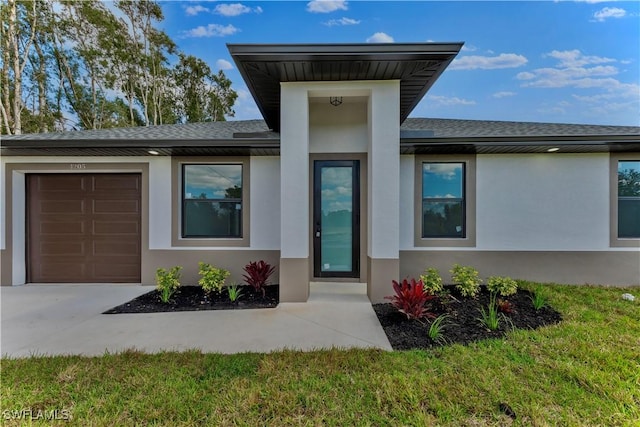 entrance to property with a garage, a shingled roof, and stucco siding