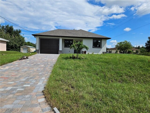 single story home featuring a front yard, decorative driveway, an attached garage, and stucco siding