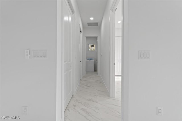 hallway with washer / dryer, visible vents, and marble finish floor