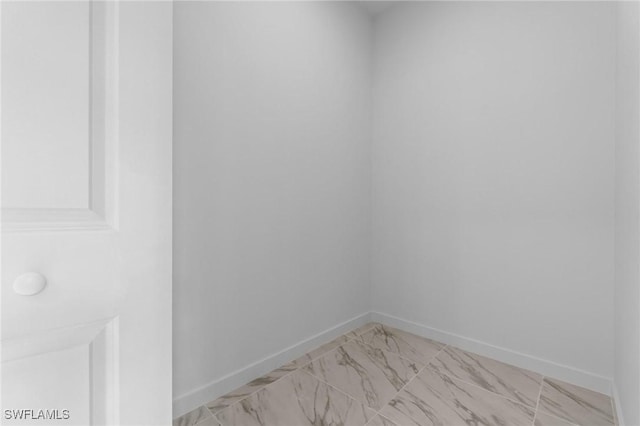 unfurnished room featuring baseboards and marble finish floor