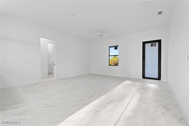 spare room with visible vents, marble finish floor, and ceiling fan