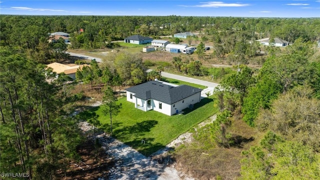 drone / aerial view with a wooded view