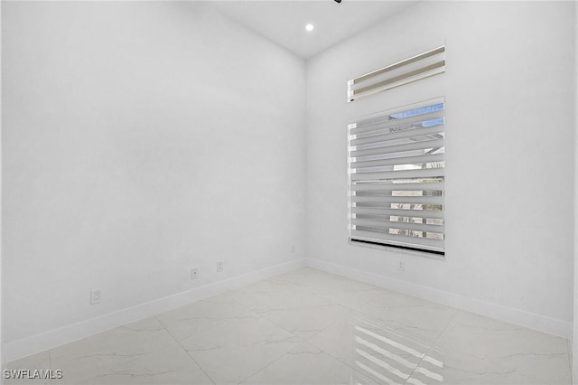 spare room featuring recessed lighting, baseboards, and marble finish floor