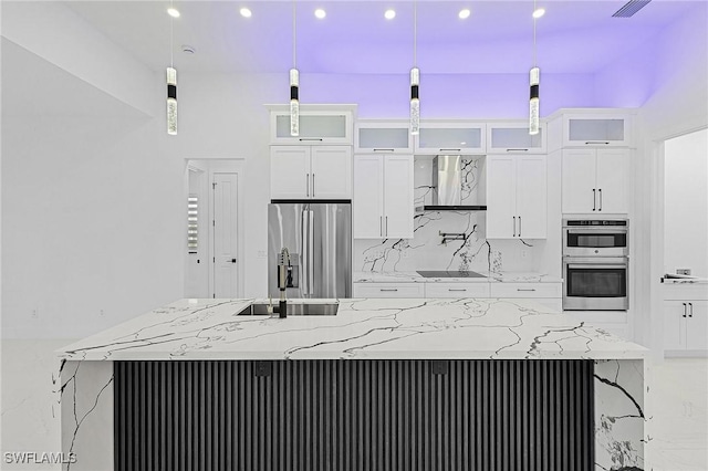 kitchen with a sink, a large island, white cabinetry, and stainless steel appliances