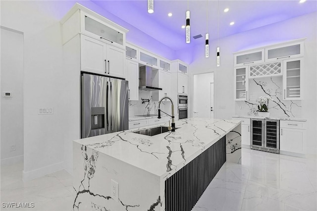 kitchen with marble finish floor, beverage cooler, a sink, white cabinetry, and appliances with stainless steel finishes