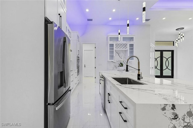 kitchen with a sink, stainless steel appliances, white cabinets, glass insert cabinets, and marble finish floor