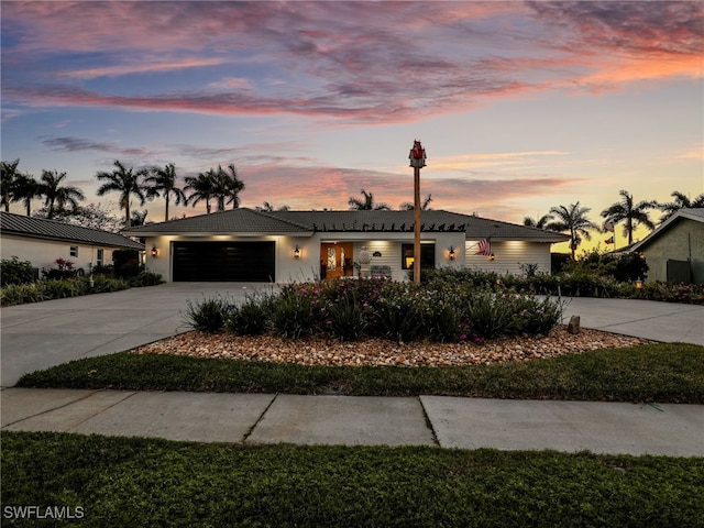 view of front facade featuring driveway, an attached garage, and a tile roof