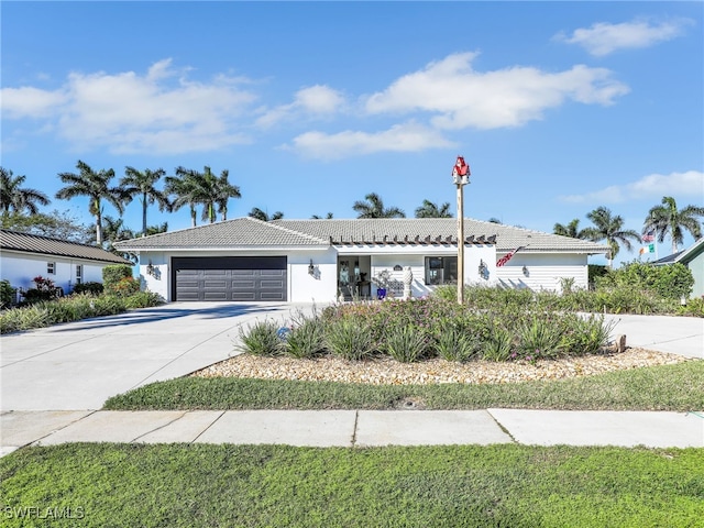 single story home with a tiled roof, an attached garage, and driveway