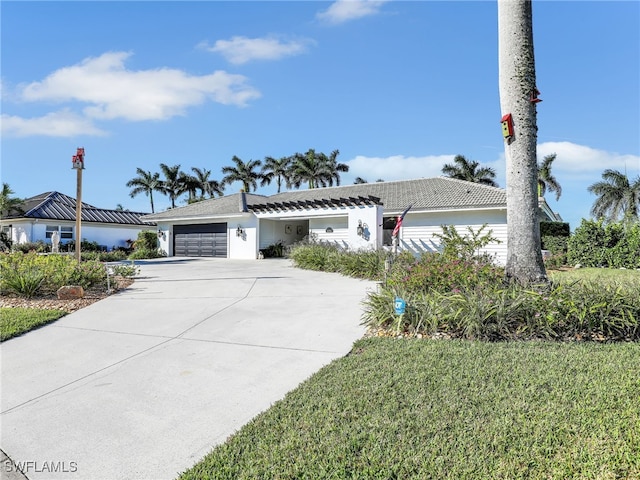 single story home with an attached garage, a tile roof, and driveway