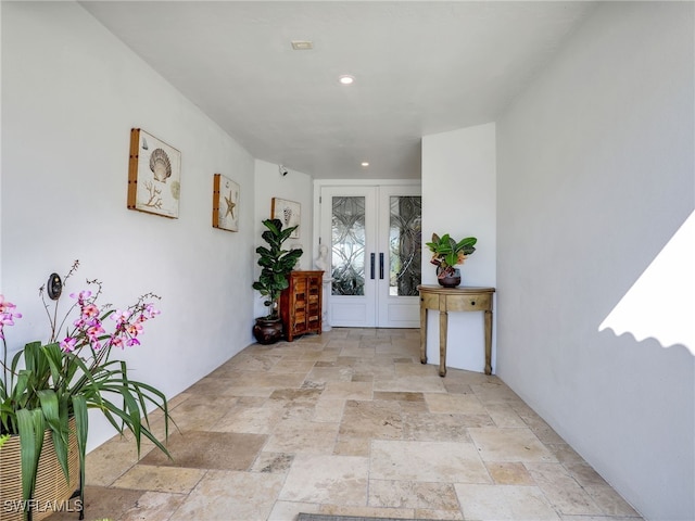 hallway featuring recessed lighting, french doors, and stone tile floors