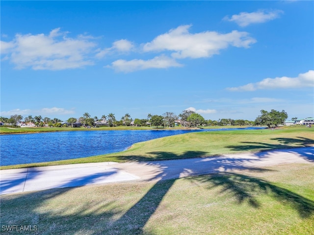 view of property's community with a lawn and a water view