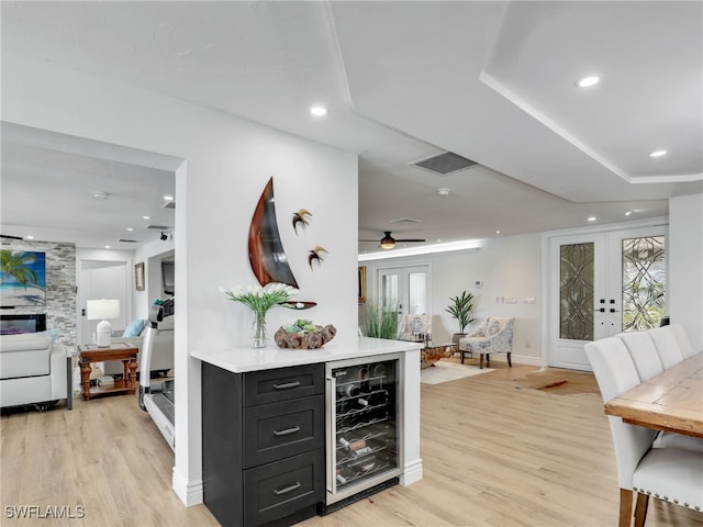 kitchen with french doors, wine cooler, light countertops, and light wood finished floors