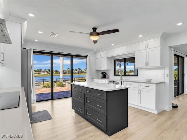 kitchen with visible vents, a ceiling fan, white cabinets, light countertops, and black electric stovetop