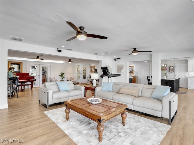 living room with visible vents, light wood-type flooring, recessed lighting, french doors, and a ceiling fan