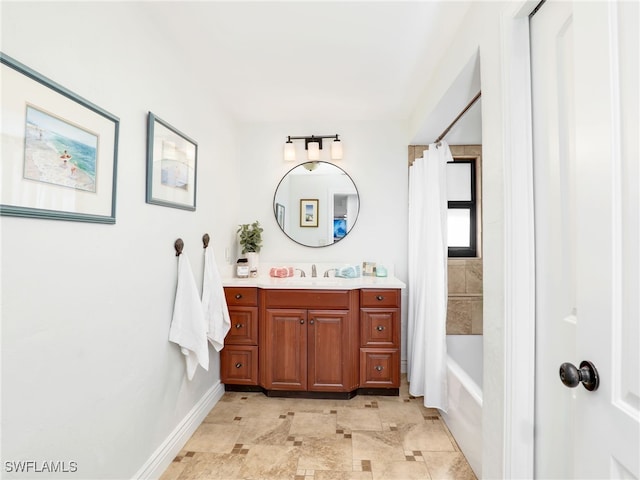 bathroom featuring vanity, shower / bath combo with shower curtain, and baseboards