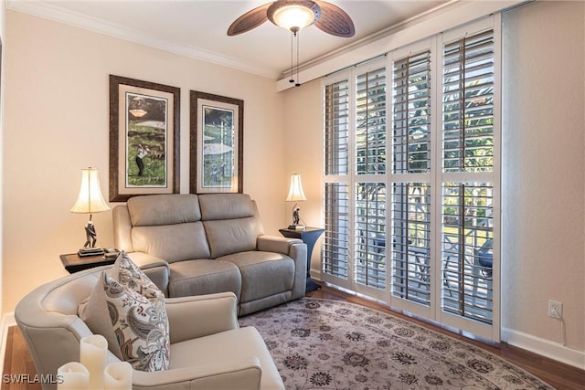 living room with crown molding, wood finished floors, a ceiling fan, and plenty of natural light