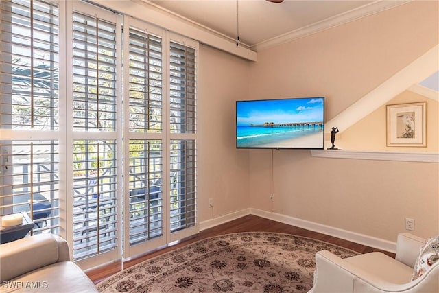 sitting room with baseboards, wood finished floors, and ornamental molding