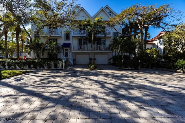 view of front of home featuring a balcony, decorative driveway, and an attached garage