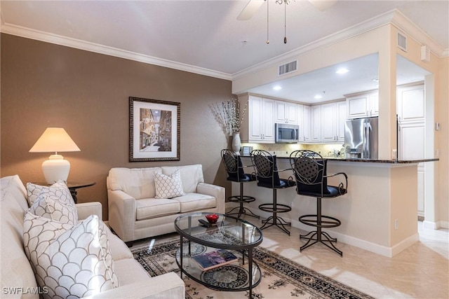 living area featuring ceiling fan, visible vents, baseboards, and ornamental molding