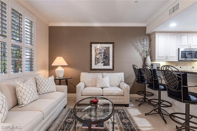 living room with crown molding, baseboards, visible vents, and a wealth of natural light