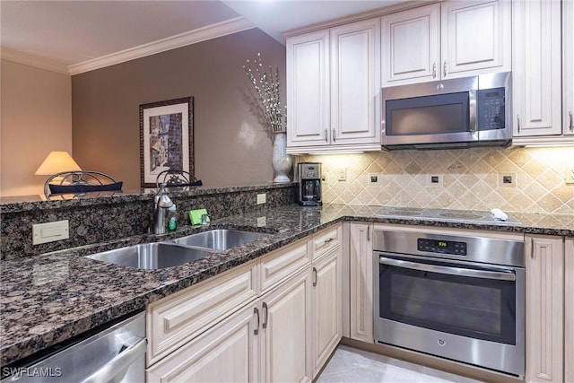 kitchen featuring tasteful backsplash, crown molding, dark stone counters, appliances with stainless steel finishes, and a sink