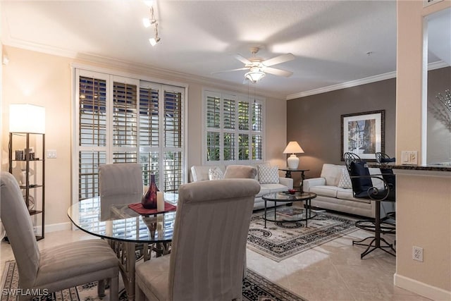 tiled dining space with a ceiling fan, baseboards, and ornamental molding