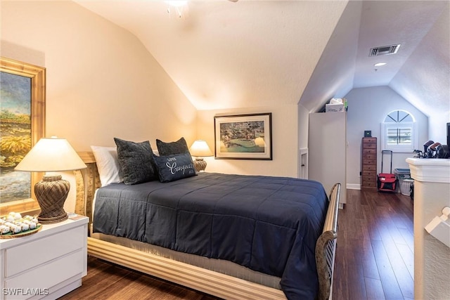 bedroom featuring visible vents, hardwood / wood-style floors, and vaulted ceiling