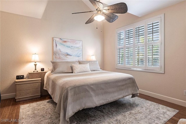 bedroom with a ceiling fan, lofted ceiling, wood finished floors, and baseboards