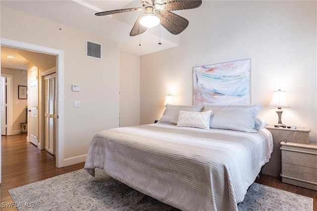 bedroom featuring visible vents, baseboards, wood finished floors, and a ceiling fan