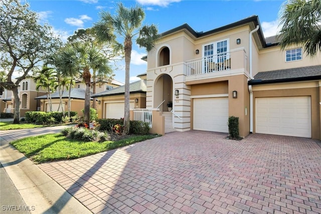 view of front of home with a balcony, driveway, and stucco siding