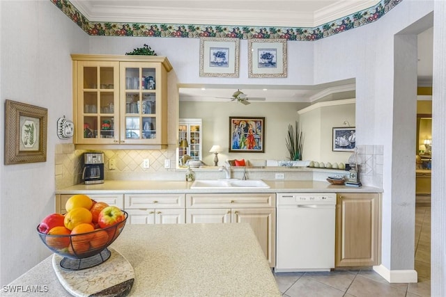 kitchen with a sink, dishwasher, crown molding, and light countertops