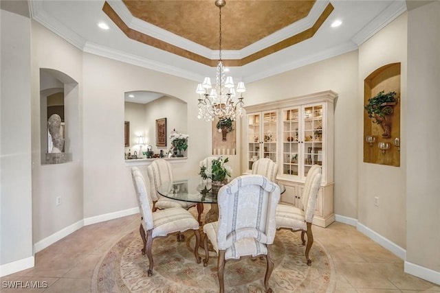 dining room featuring tile patterned flooring, a raised ceiling, baseboards, and ornamental molding