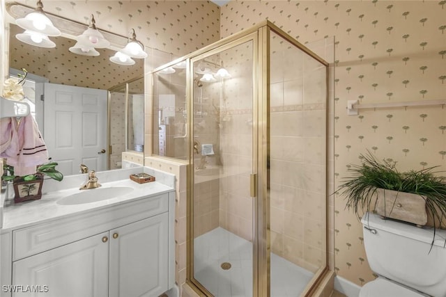 bathroom with a shower stall, wallpapered walls, vanity, and toilet