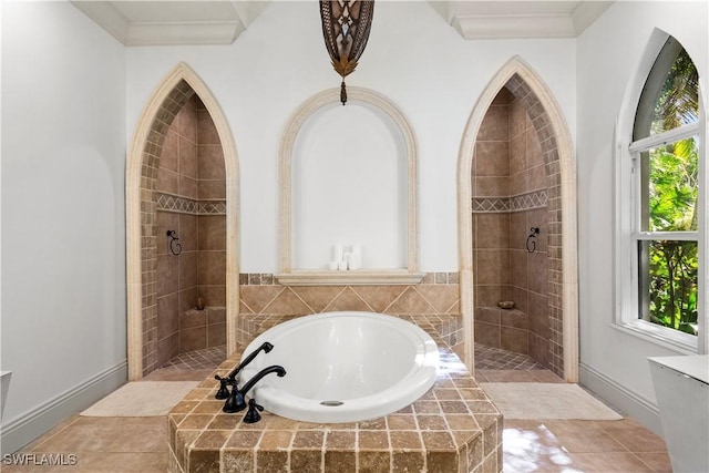 bathroom with baseboards, a bath, crown molding, and a tile shower