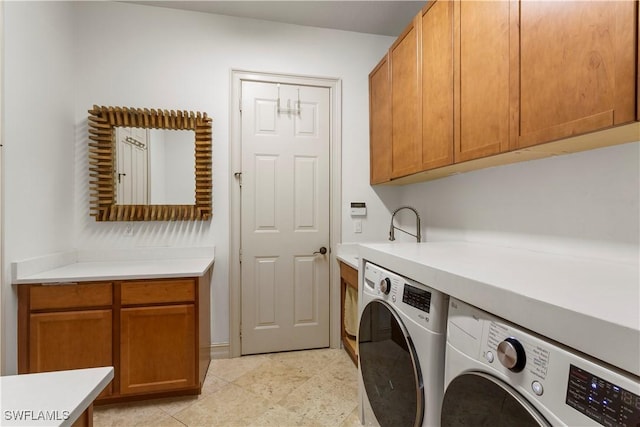 laundry room with washer and dryer, cabinet space, and a sink