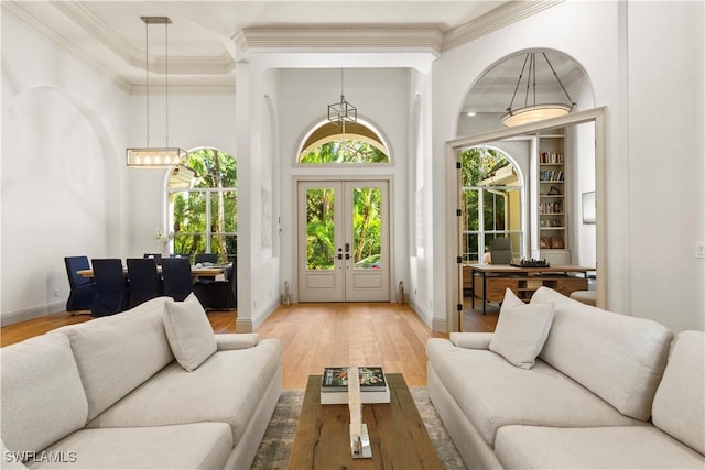 interior space with wood finished floors, crown molding, french doors, and baseboards