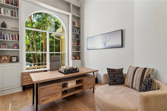 sitting room with built in features and wood-type flooring