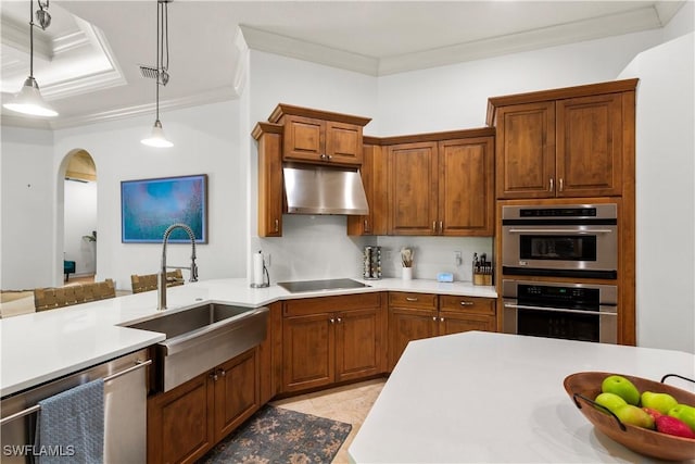 kitchen featuring a sink, stainless steel appliances, light countertops, under cabinet range hood, and pendant lighting