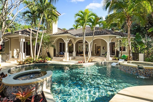 view of pool featuring a patio area, a pool with connected hot tub, and fence