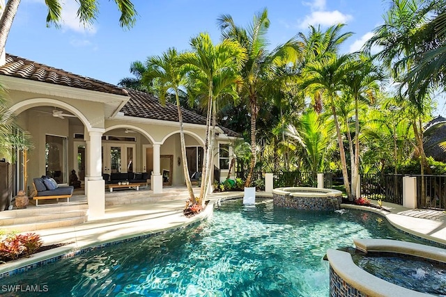 view of pool featuring an outdoor living space, a pool with connected hot tub, fence, a ceiling fan, and a patio