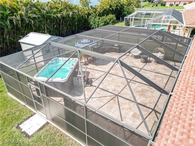 view of pool featuring glass enclosure and a patio area