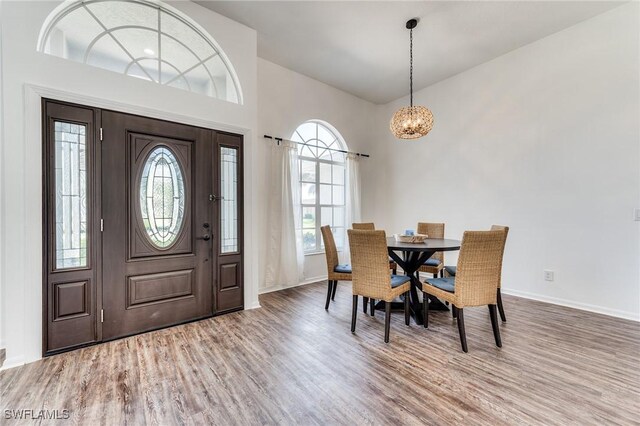 dining area with baseboards, a notable chandelier, and wood finished floors